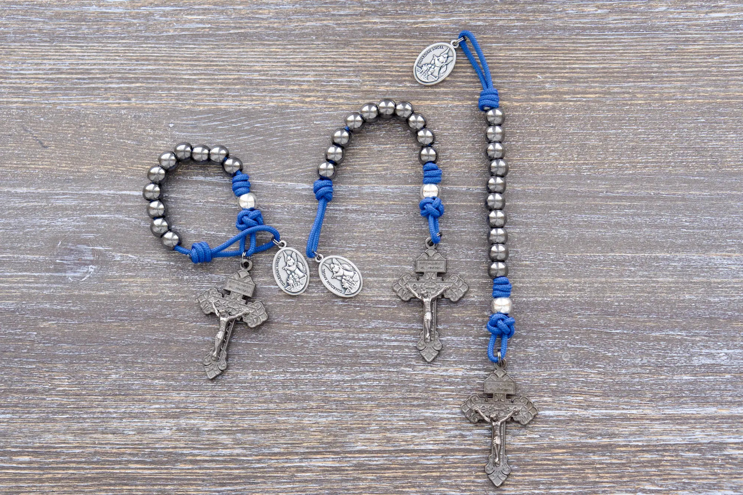 Premium metal beaded pocket paracord rosary featuring blue rope, gunmetal pardon crucifix, gunmetal and silver metal alloy beads.