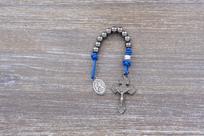 Guardian of Grace pocket paracord rosary with blue rope, gunmetal crucifix, and silver alloy beads – premium metal beaded design.