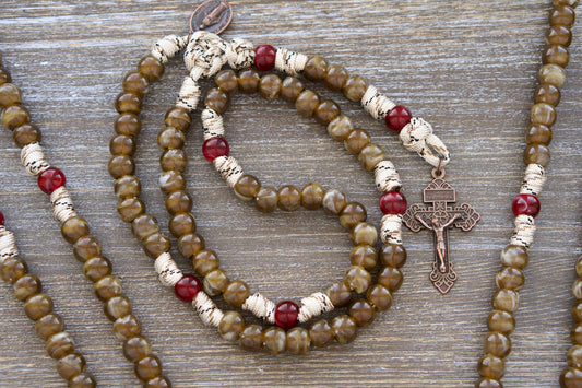 A handcrafted brown camo paracord rosary featuring creamy brown Hail Mary beads, creamy maroon Our Father beads, a copper Miraculous Medal, and a 2-inch antique copper Pardon crucifix. Measuring 19 inches long.