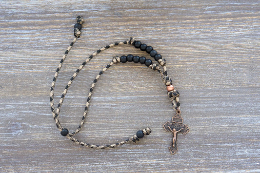 Heavy Duty Hail Mary rearview mirror rosary hangs securely, showcasing 10mm matte black and antique copper beads on rugged 550 paracord with a copper crucifix.