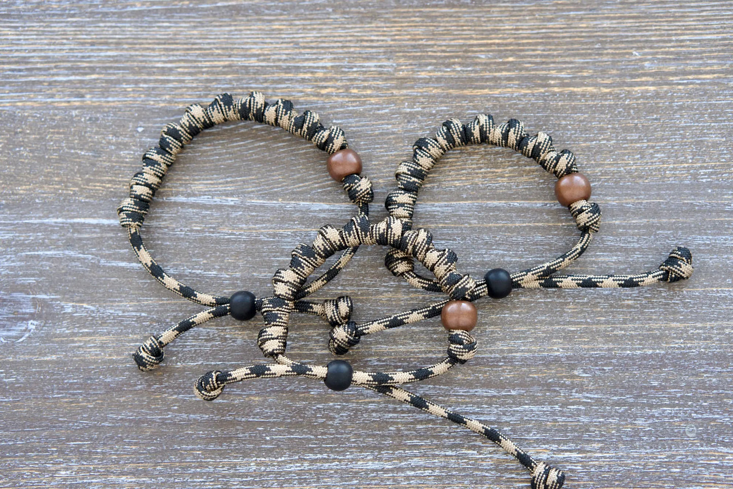 Hail Mary rosary bracelet with black/brown camo paracord and bold beads—each knot holds a Hail Mary prayer!