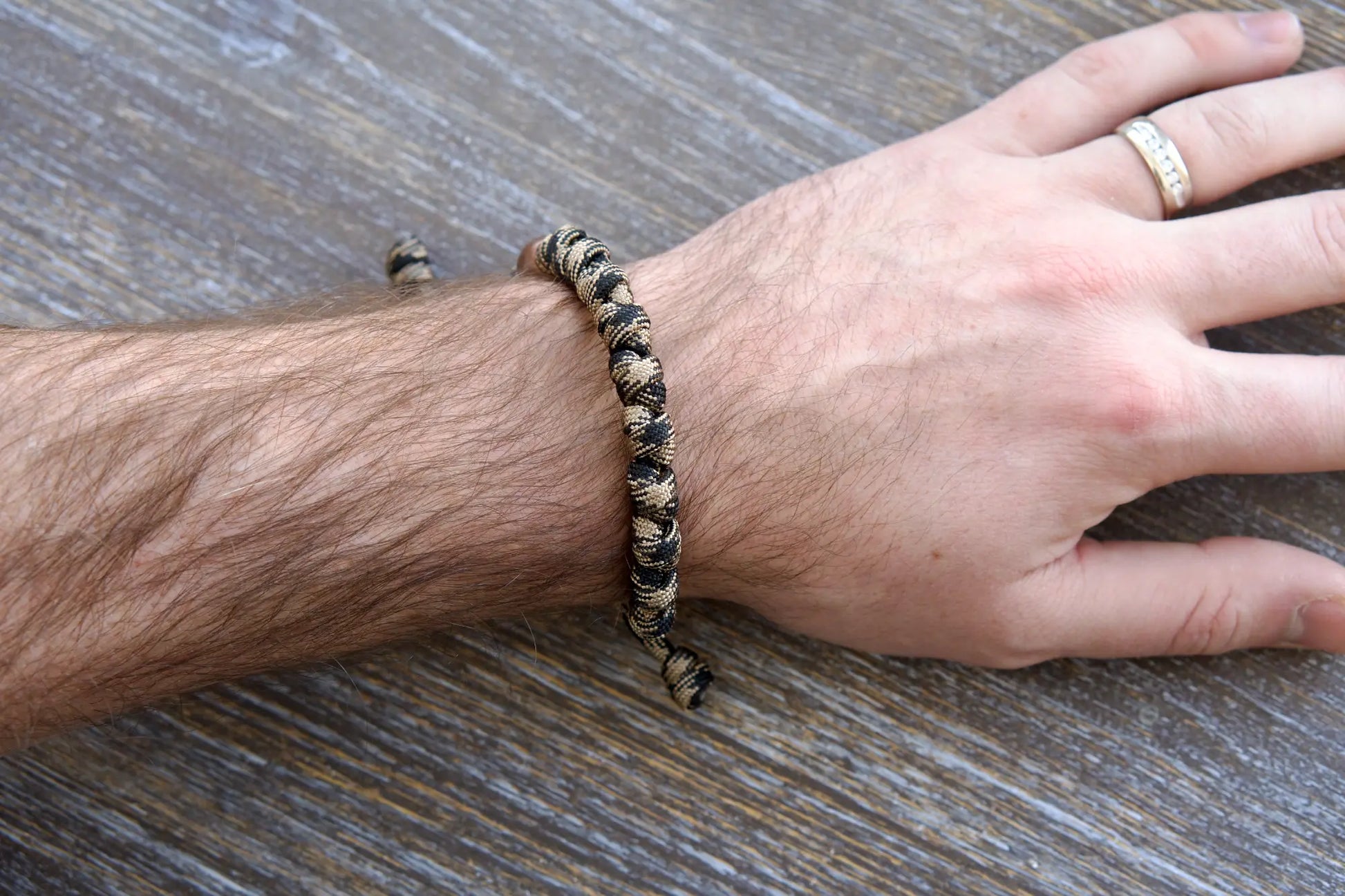 The Heavy Duty Hail Mary Rosary Bracelet: black/brown camo paracord, 12mm and 10mm acrylic beads, each knot representing a Hail Mary prayer.