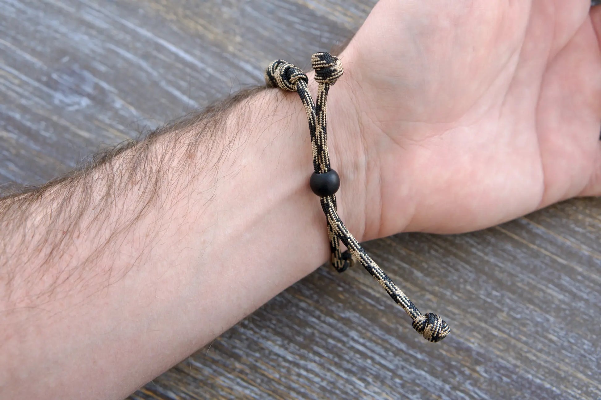 Heavy Duty Hail Mary rosary bracelet: black/brown camo paracord, 12mm and 10mm acrylic beads, adjustable, rugged and faithful.