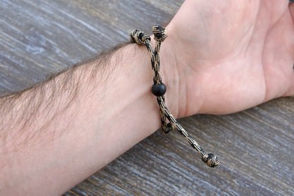 Heavy Duty Hail Mary rosary bracelet: black/brown camo paracord, 12mm and 10mm acrylic beads, adjustable, rugged and faithful.