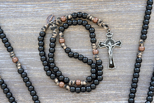 Rugged paracord 550 rosary in copper and coffee hues with 12mm beads, black enamel St. Benedict crucifix, and copper Miraculous Medal.