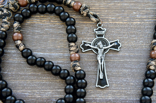 This black paracord rosary features a copper Miraculous Medal, 12mm coffee and copper beads, and a St. Benedict crucifix for spiritual strength.