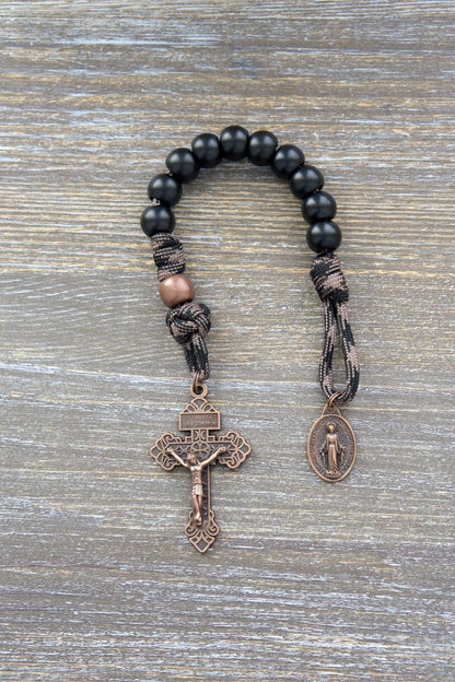 Heavy Duty Hail Mary Pocket Rosary: Matte black acrylic beads, antique copper Our Father bead, crucifix, and Miraculous Medal on paracord cord.