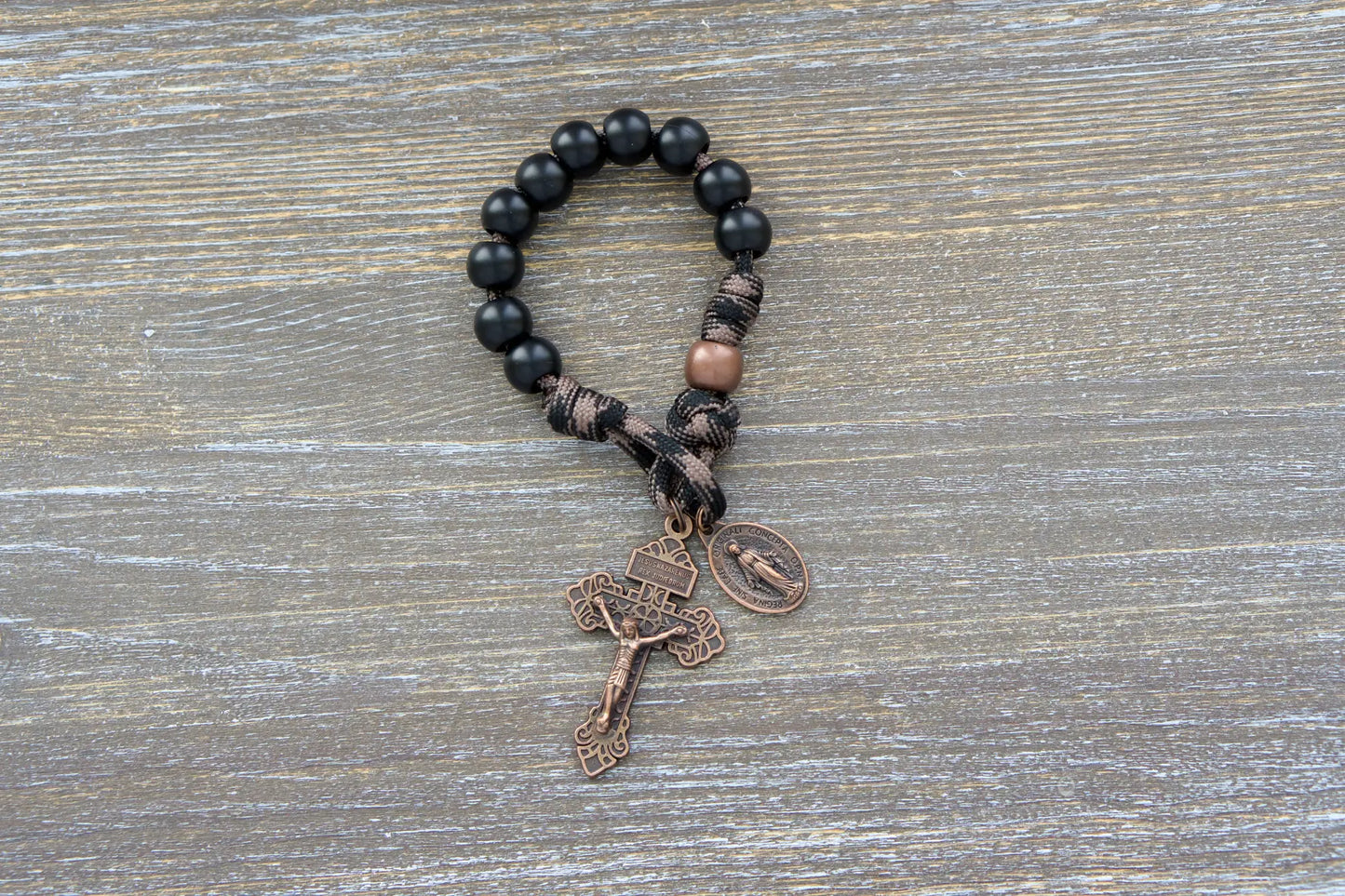 Heavy Duty Hail Mary Pocket Rosary: black acrylic Hail Mary beads, antique copper Our Father bead, crucifix, and Miraculous Medal on durable paracord cord.