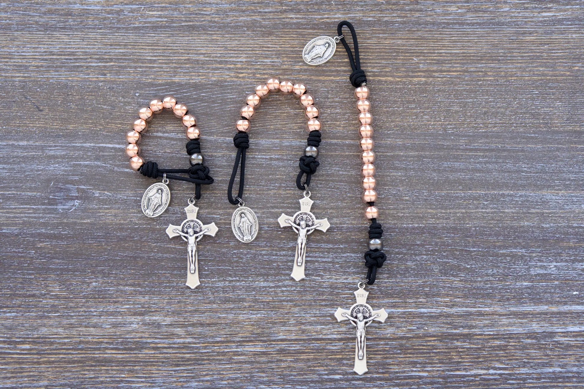 Immaculate Strength premium metal beaded pocket paracord rosary featuring black paracord rope and rose gold metal alloy beads.