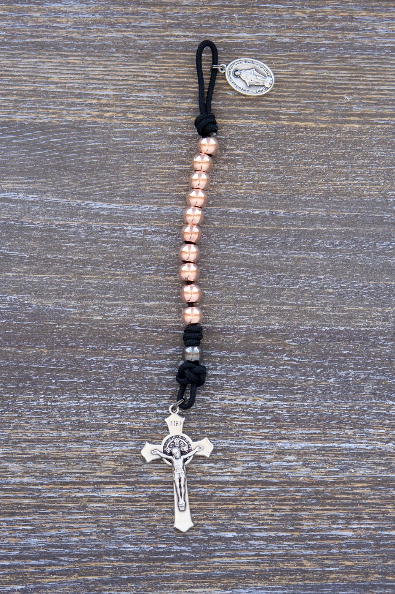 Immaculate Strength premium metal paracord rosary with black rope and rose gold beads, designed for strength and faith.