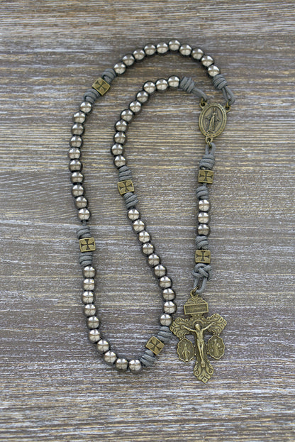 Premium grey paracord rosary, "Iron Crusader" design, featuring olive metal Our Father beads, gunmetal Hail Mary beads, a Miraculous Medal centerpiece, and a matching olive crucifix. 