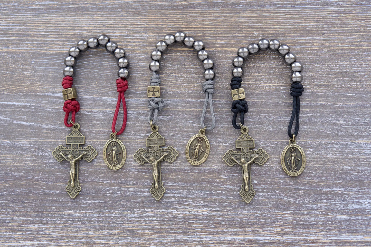 Iron Crusader pocket paracord rosary in midnight black, iron grey or maroon featuring olive crucifix, metal beads, and Miraculous Medal centerpiece.