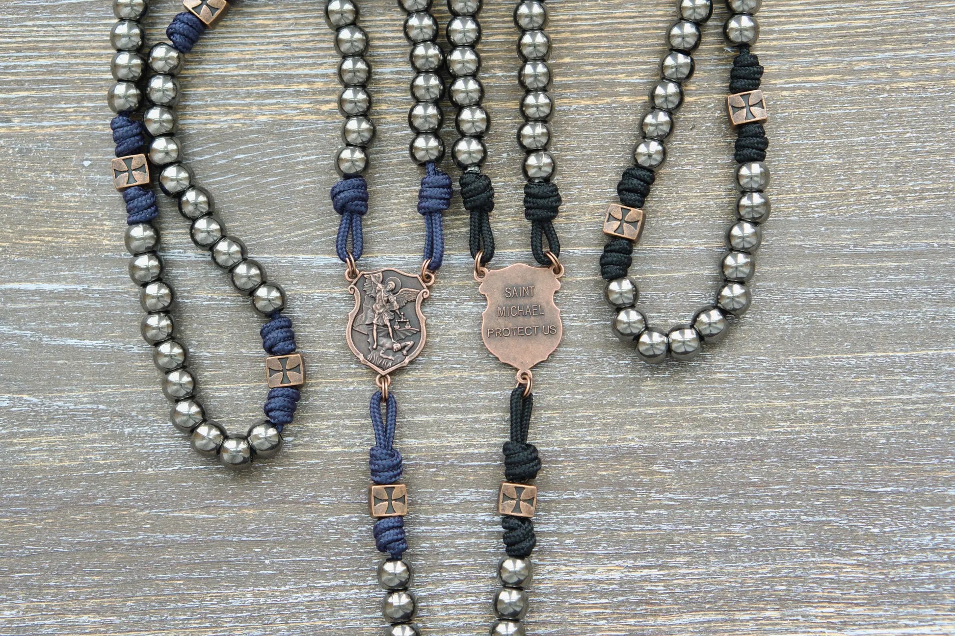 Black or navy blue paracord rosary featuring 10mm gunmetal Hail Mary beads, copper accents, and a St. Michael centerpiece medal.  