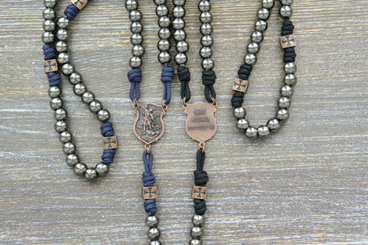 Black or navy blue paracord rosary featuring 10mm gunmetal Hail Mary beads, copper accents, and a St. Michael centerpiece medal.  