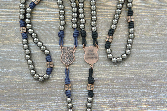 Black or navy blue paracord rosary featuring 10mm gunmetal Hail Mary beads, copper accents, and a St. Michael centerpiece medal.  