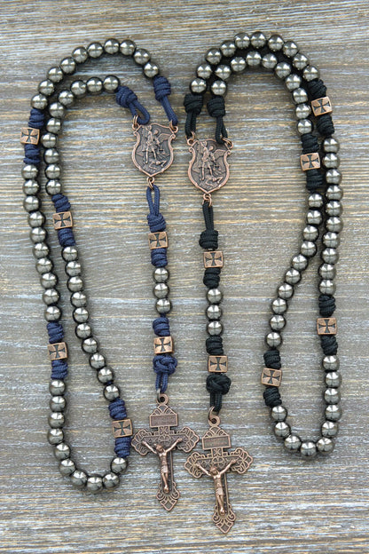 Black or navy blue paracord rosary featuring gunmetal Hail Mary beads, copper Our Father beads, St. Michael centerpiece medal, and crucifix.