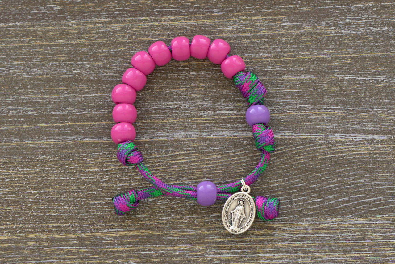 Judith's Sword Kid's Rosary Bracelet by Sanctus Servo - Handmade purple and green paracord bracelet with 5 decade rosary, pink acrylic beads for Hail Mary prayers, matching purple Our Father bead, Miraculous Medal.