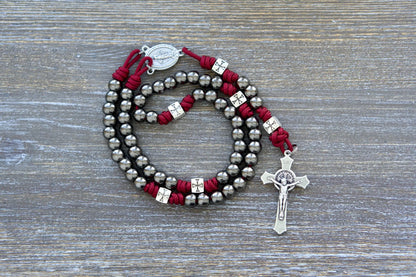 Last Stand Rosary: Gunmetal Hail Mary beads, silver crusader Our Father beads, Miraculous Medal centerpiece, and St. Benedict crucifix on red paracord.