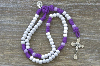 Little Flowers of Jesus - Kid's Paracord Rosary: A stylish and durable Catholic gift for young hearts, featuring high-quality purple paracord rope, light purple accent Our Father beads, white Hail Mary beads, a 2-inch St. Benedict crucifix, and a Miraculous Medal.