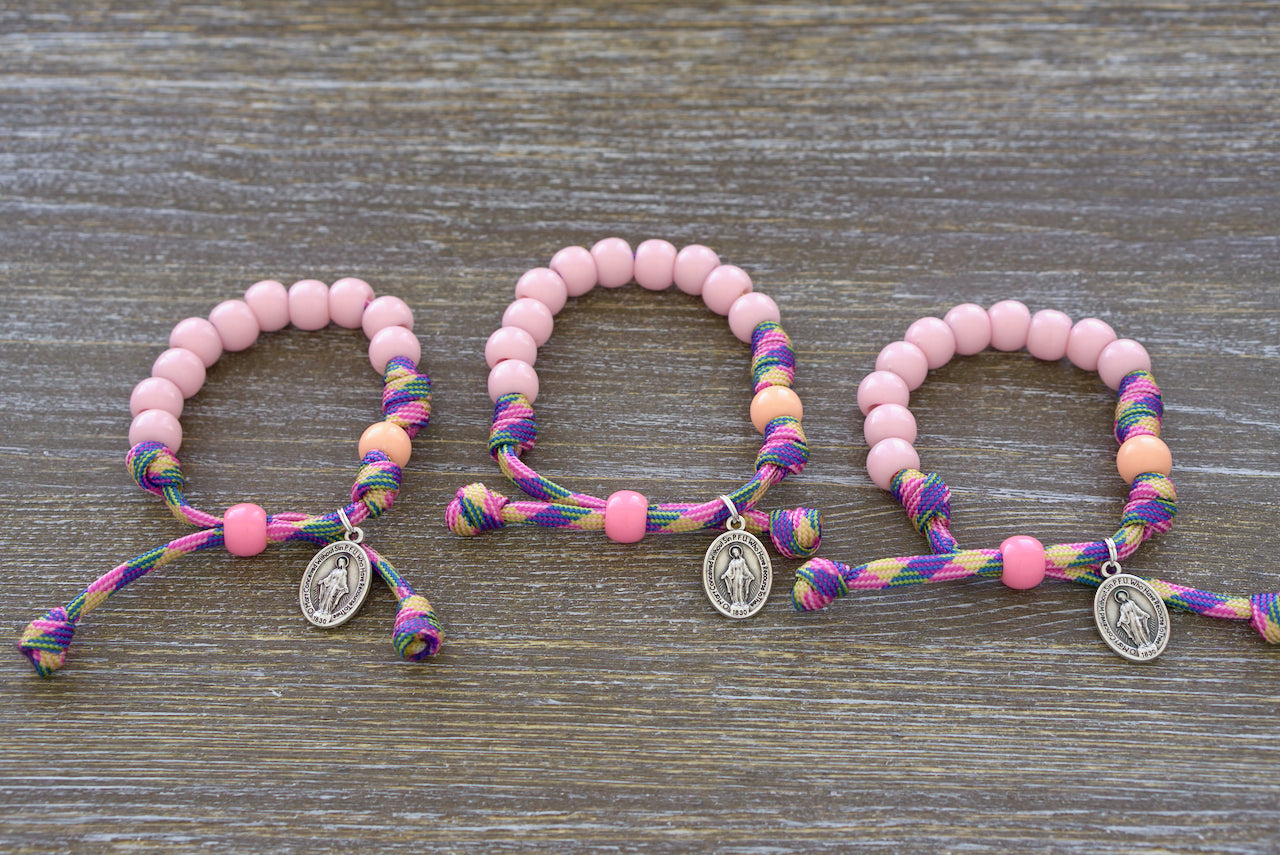 Little Lady's Miracle - Kid's Rosary Bracelet: A beautifully crafted pink/green/orange paracord rosary bracelet with petite 10mm pink beads, matching orange Our Father beads, and a tiny Miraculous Medal charm for children's spiritual journey.