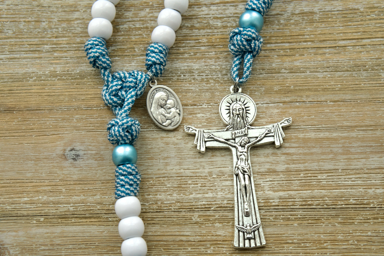 Beautiful blue and white striped paracord rosary featuring the Mater Boni Consilii (Our Lady of Good Counsel) and Holy Trinity devotional medals, alongside a 3-inch Holy Trinity crucifix. A premium and durable Catholic gift for prayer and spiritual guidance.