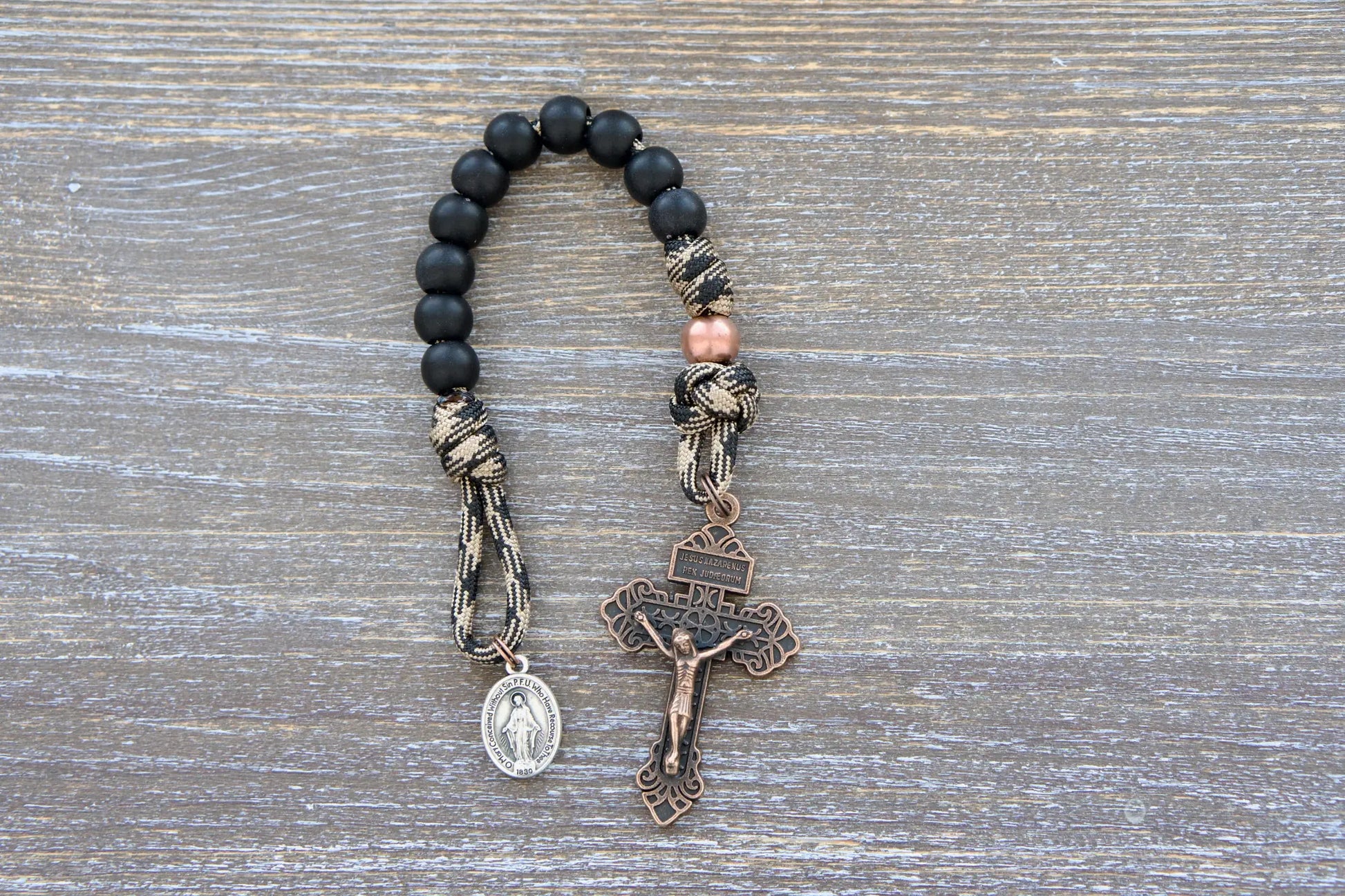 Kid's Mini Duty Hail Mary rosary with camo paracord, matte black beads, copper accent beads, crucifix, and miraculous medal.