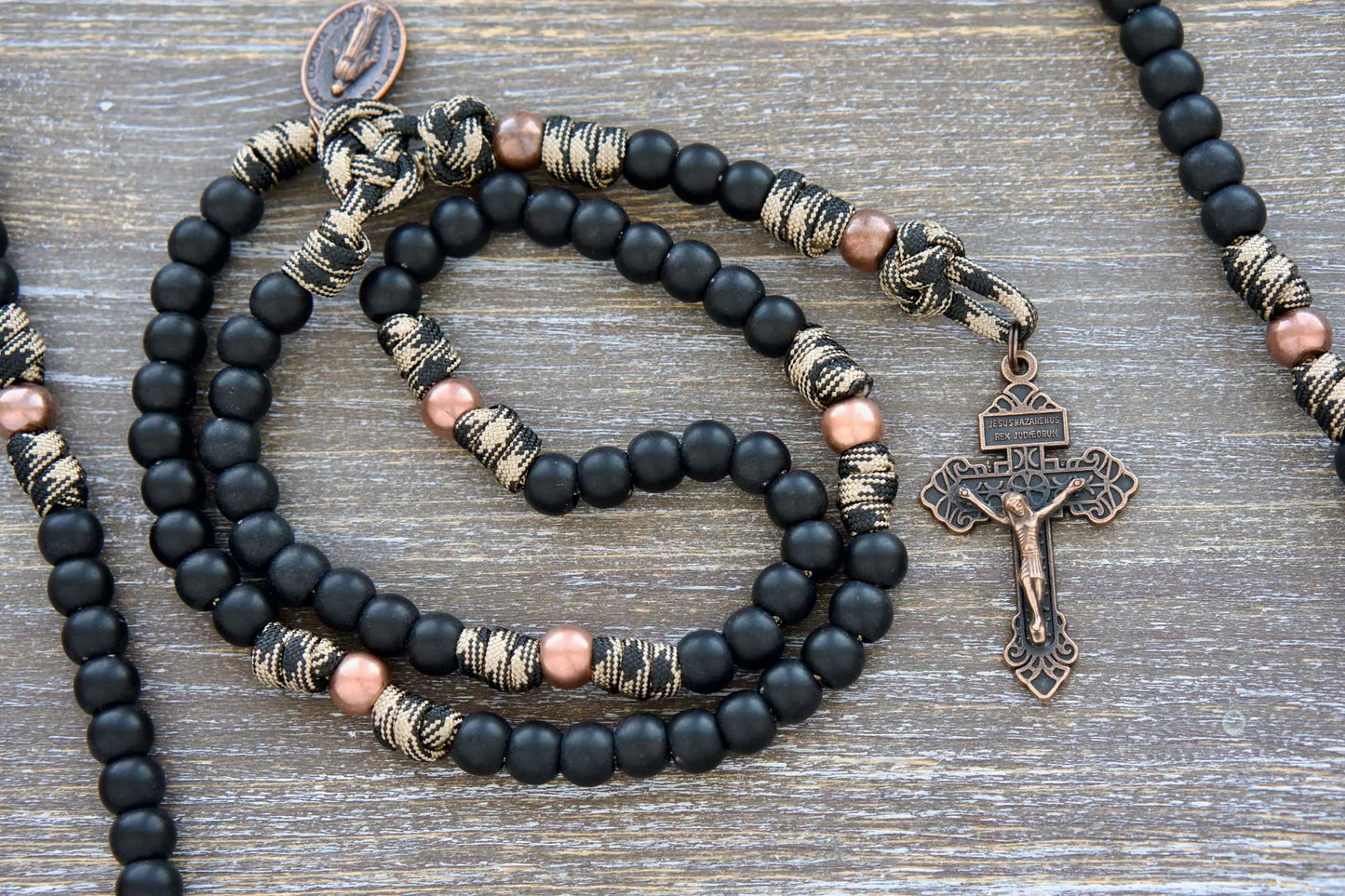 Mini Duty Hail Mary rosary in camo black and brown paracord with 10mm matte black and antique copper beads, finished with a copper Pardon crucifix and miraculous medal.