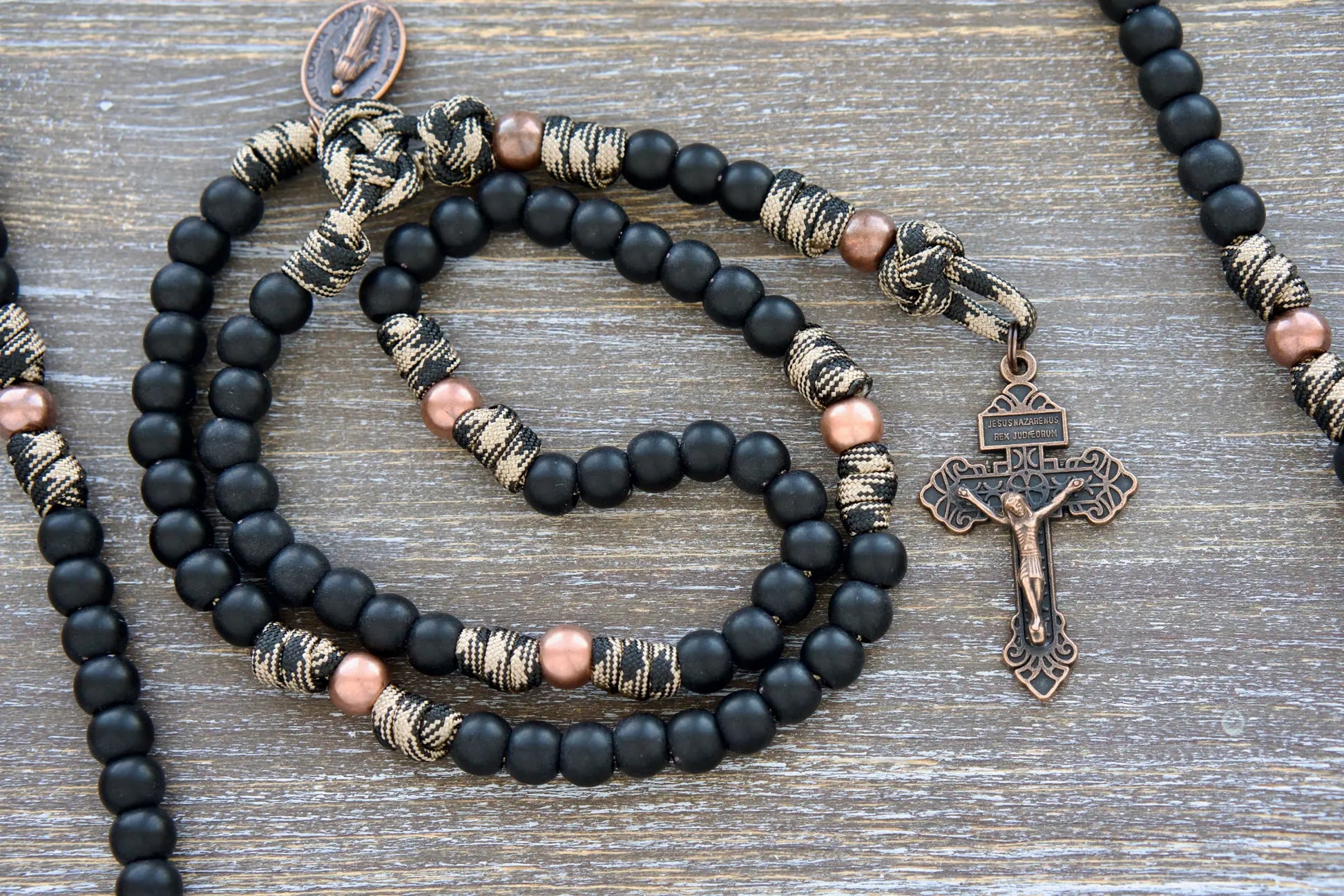 Mini Duty Hail Mary rosary in camo black and brown paracord with 10mm matte black and antique copper beads, finished with a copper Pardon crucifix and miraculous medal.