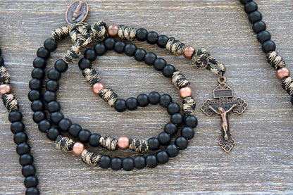 Mini Duty Hail Mary rosary in camo black and brown paracord with 10mm matte black and antique copper beads, finished with a copper Pardon crucifix and miraculous medal.