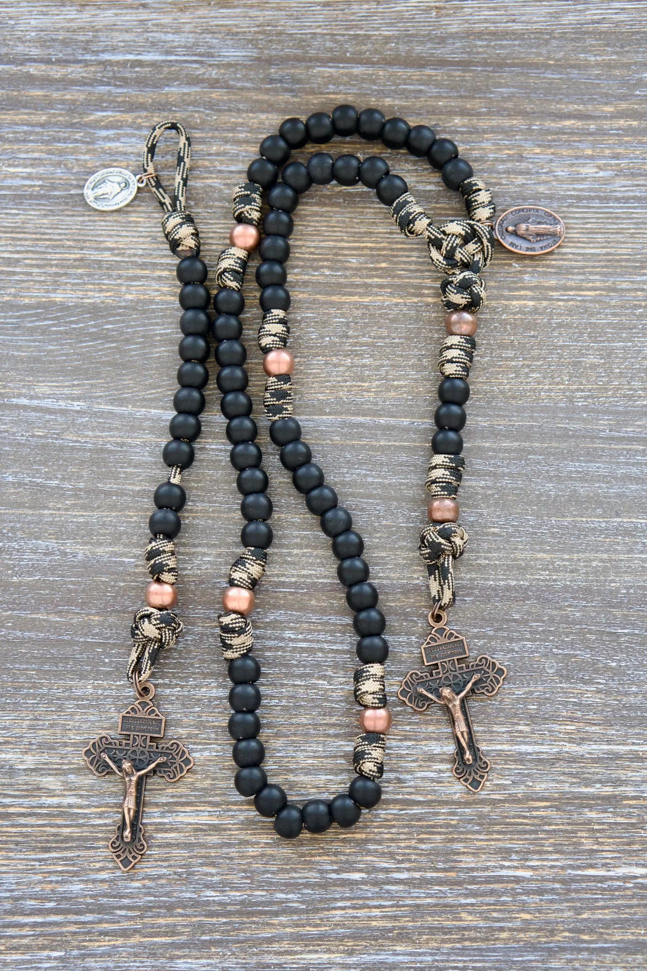 This kid's Mini Duty Hail Mary rosary features rugged camo black and brown 550 paracord, small 10mm matte black beads, copper accents, and a Pardon crucifix.