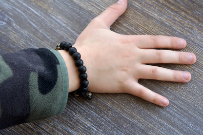 Rugged black acrylic rosary bracelet for kids featuring a Miraculous Medal and antique copper Our Father bead on durable paracord.