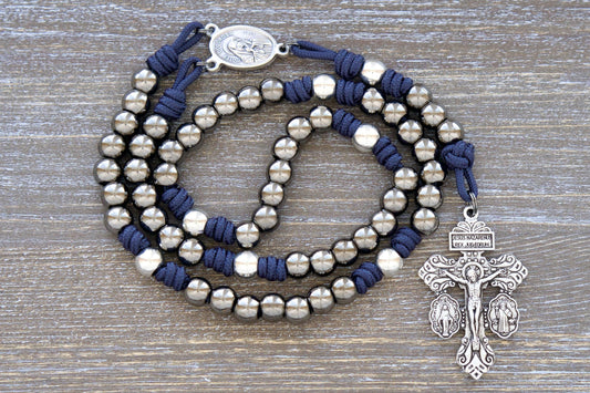 Navy blue paracord Servite Rosary chaplet featuring silver and gunmetal metal alloy beads, Mater Dolorosa/Ecce Homo centerpiece medal, and a triple crucifix.  Handmade with premium materials for enduring spiritual devotion.