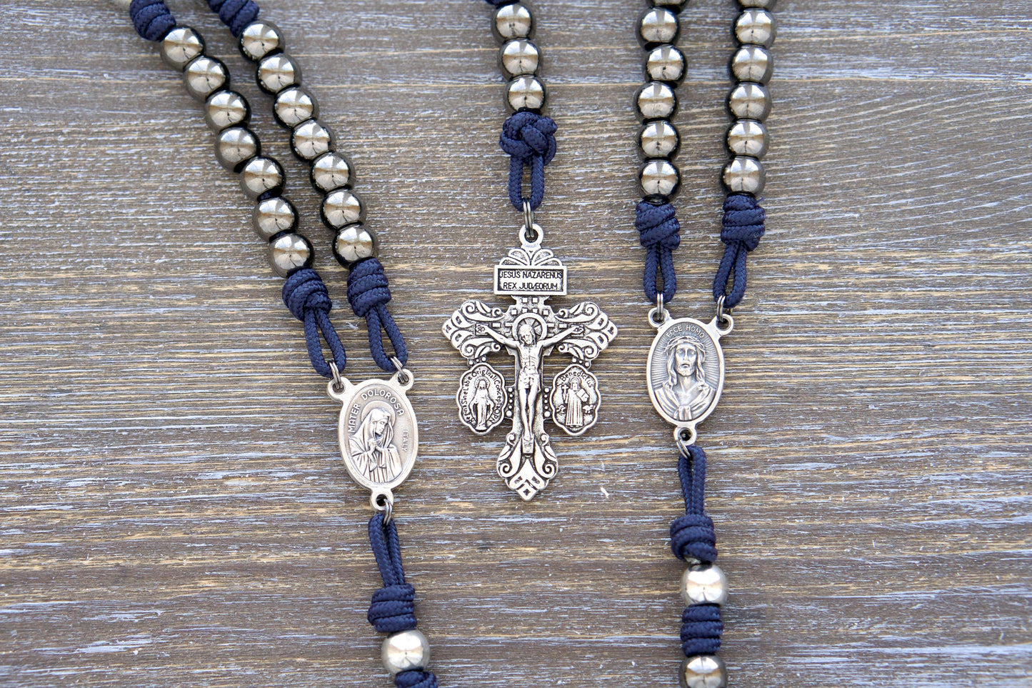 Navy blue paracord Servite Rosary chaplet with gunmetal Hail Mary beads, silver Our Father beads, a Mater Dolorosa and Ecce Homo centerpiece, and a triple-threat pardon crucifix. Handmade rosary for fervent devotion and spiritual strength.