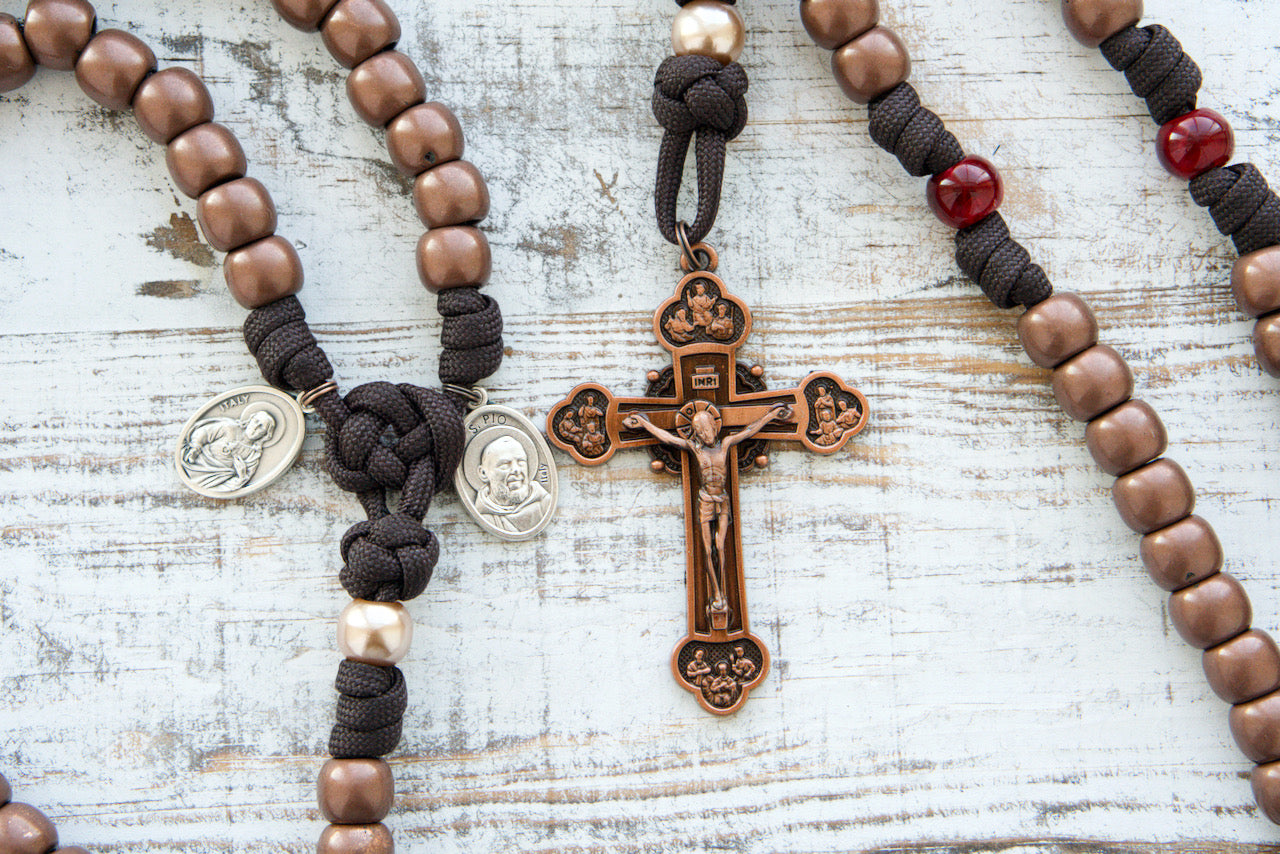 St. Padre Pio's Intercession - 5 Decade Paracord Rosary in Brown, Red, and Antique Copper Hues, Honoring St. Padre Pio's Devotion to Christ's Suffering with Four Maroon Our Father Beads Representing His Stigmata Wounds, Featuring Sacred Heart of Jesus and St. Padre Pio Medals, and a Heavy Duty Copper Crucifix - Catholic Gift for Faith Deepening and Devotion.