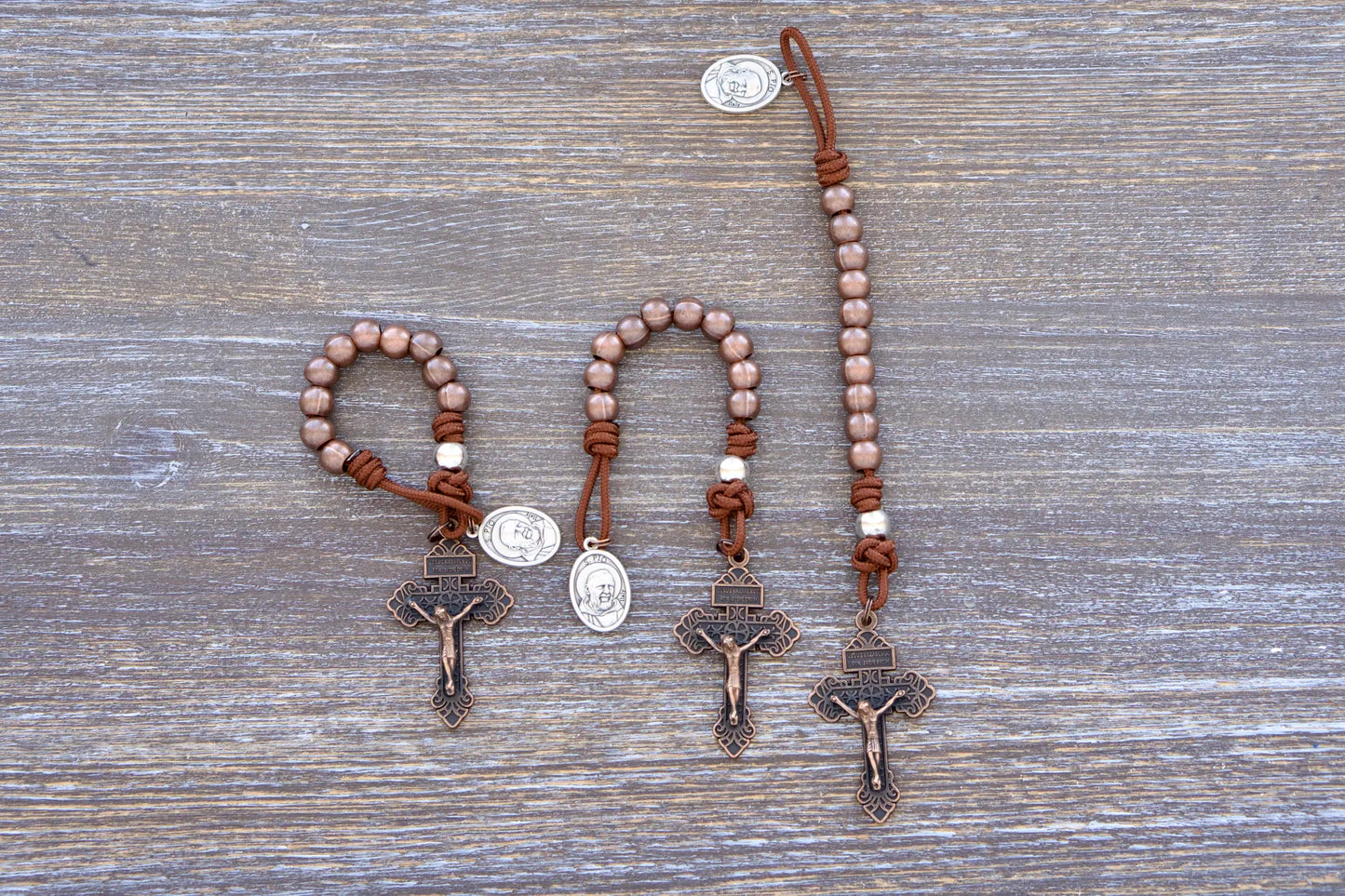 St. Padre Pio Premium Metal Pocket Paracord Rosary with antique copper Hail Mary beads, silver Our Father bead and copper pardon crucifix.