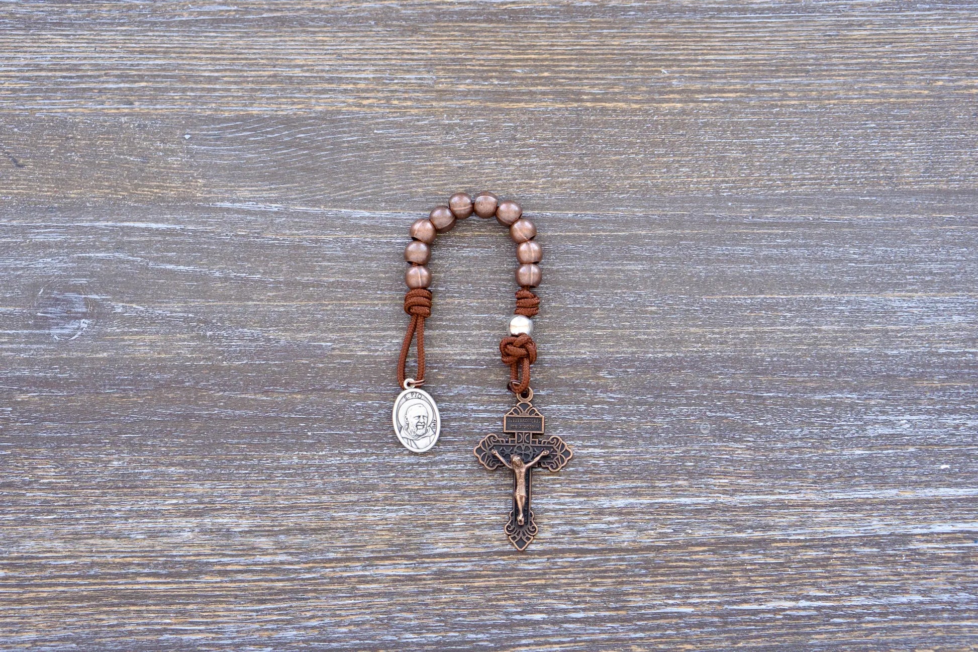 St. Padre Pio Premium Metal Paracord Rosary with copper Hail Mary beads, silver Our Father bead, and copper pardon crucifix.