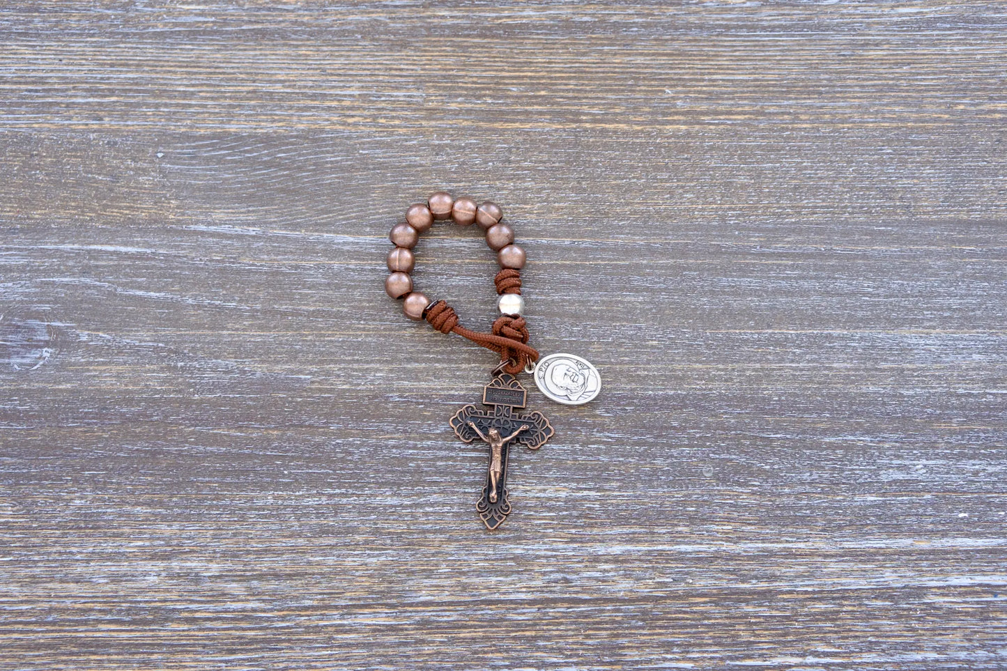 St. Padre Pio Premium Metal Paracord Rosary with copper Hail Mary beads, silver Our Father bead, and copper pardon crucifix.