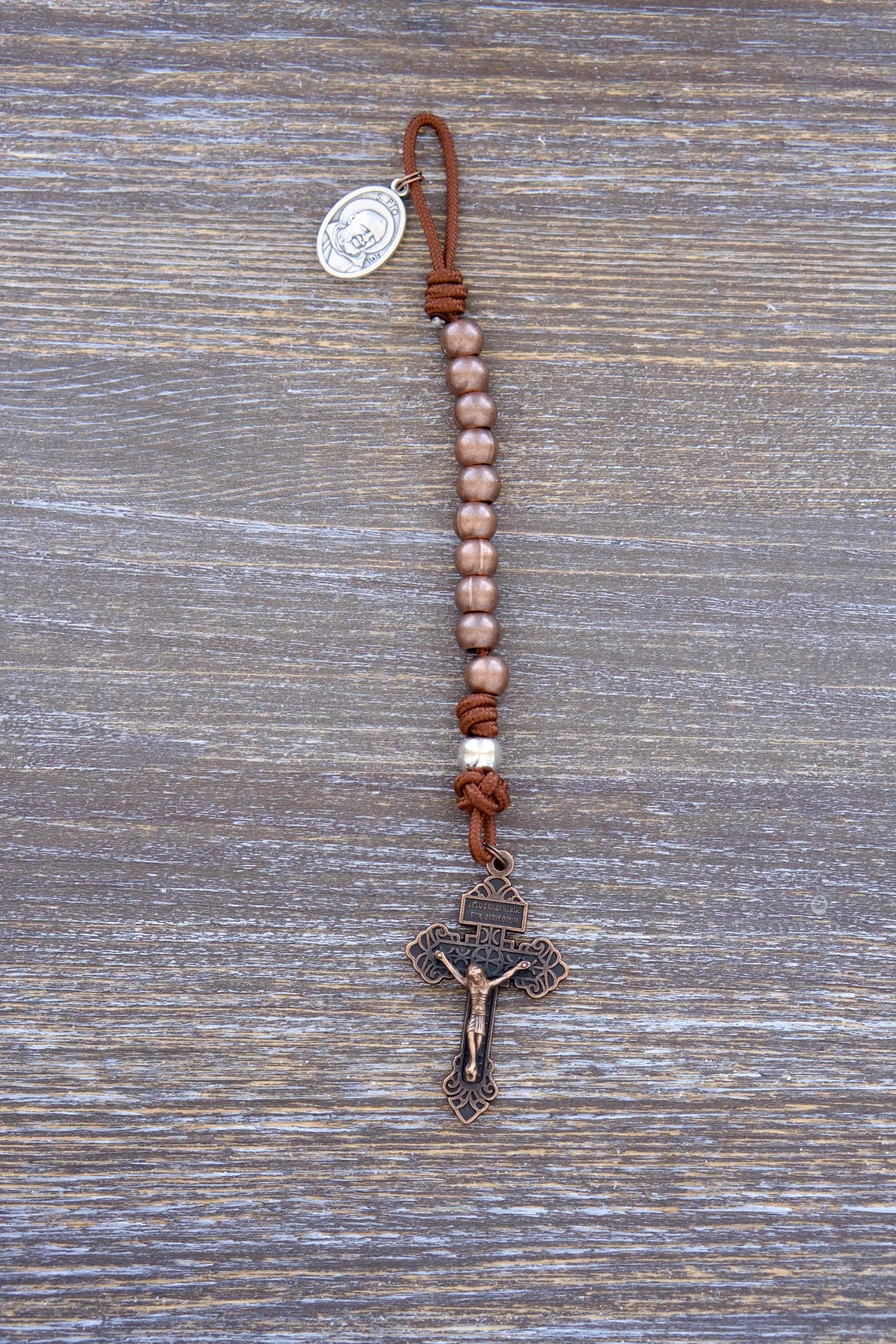 St. Padre Pio Premium Metal Pocket Paracord Rosary with copper Hail Mary beads, silver Our Father bead, and copper pardon crucifix.