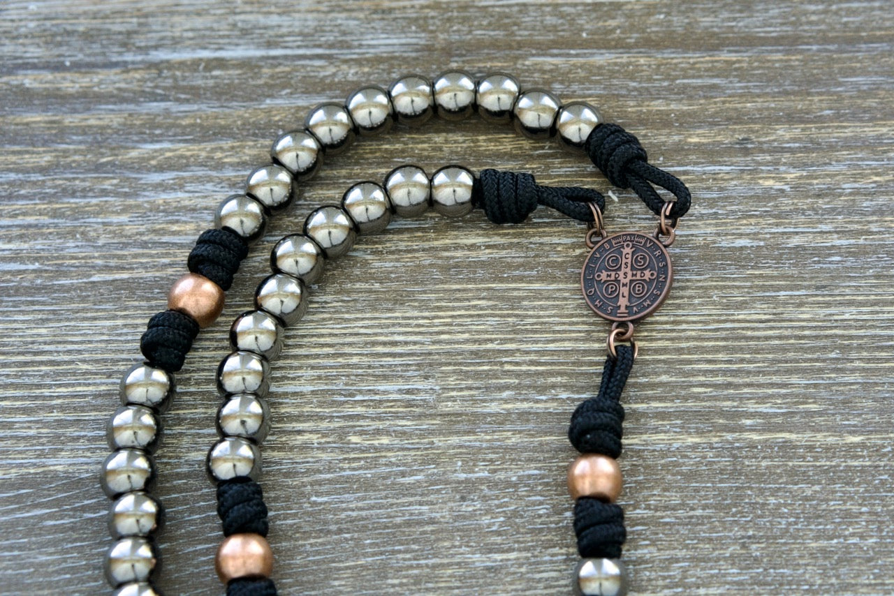 Stronghold of Grace | Gunmetal, Gold and Black Premium Metal Rosary with durable Paracord 275, featuring a stunning design and powerful St. Benedict centerpiece for unbreakable faith on life's battles. Perfect Catholic gift for men.