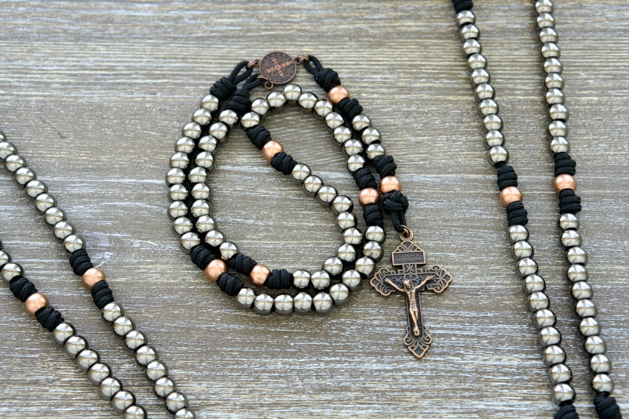 Stronghold of Grace | Gunmetal, Gold and Black Premium Metal Rosary with 10mm Alloy Beads and High-Quality Paracord. A durable Catholic rosary featuring a St. Benedict centerpiece and Pardon Crucifix for protection and inspiration in your daily faith journey.