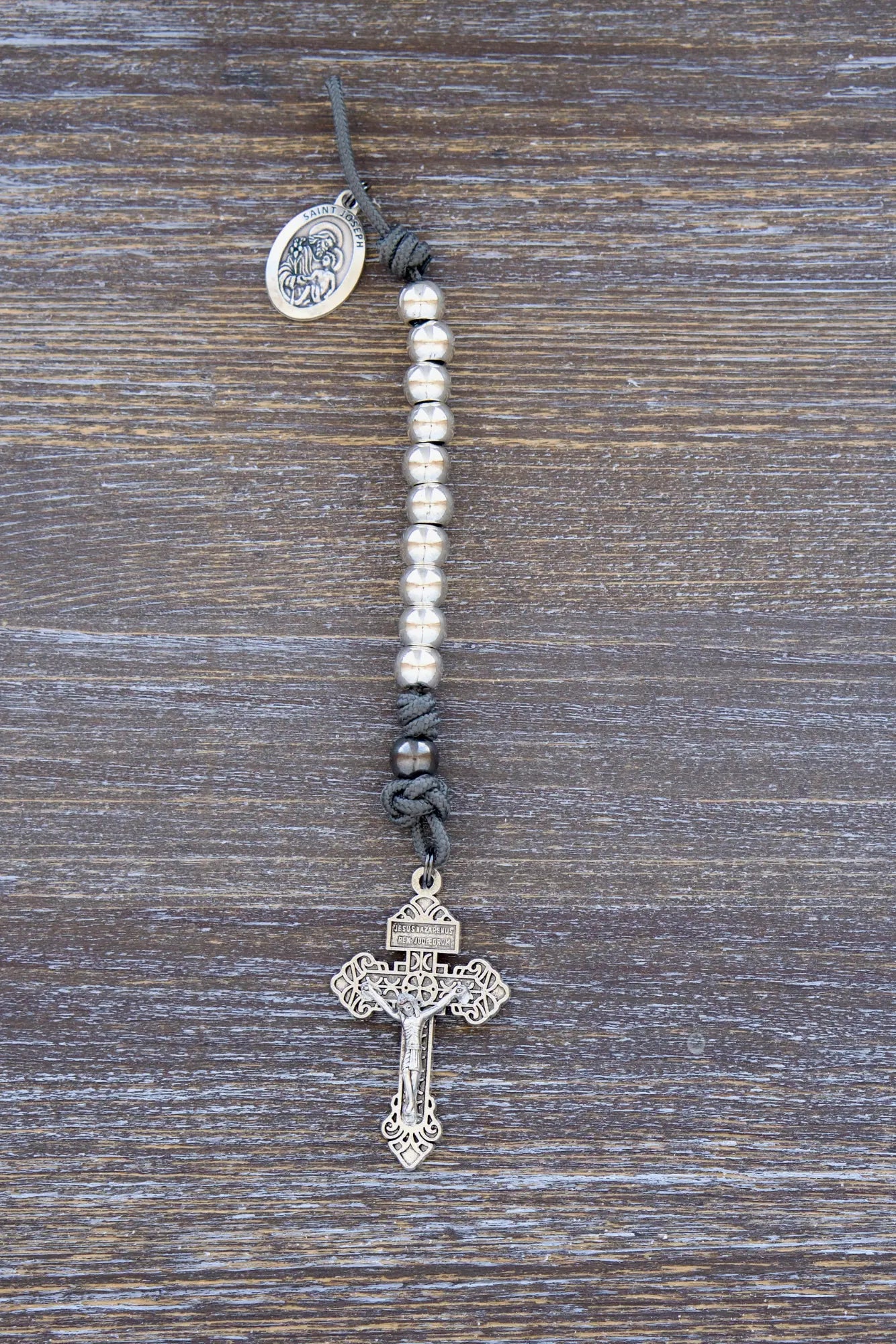Premium metal paracord rosary with gray rope, silver beads, St. Joseph medal, and pardon crucifix.