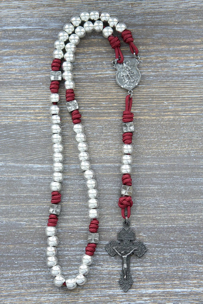Metal paracord rosary with gunmetal St. Michael centerpiece, crucifix, and Hail Mary beads in iron crimson red rope color.