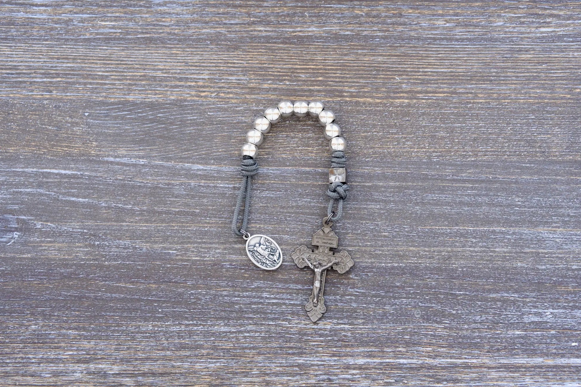 Reclaim Christendom rosary in premium metal paracord with gunmetal crucifix, available in navy, maroon, or iron gray.