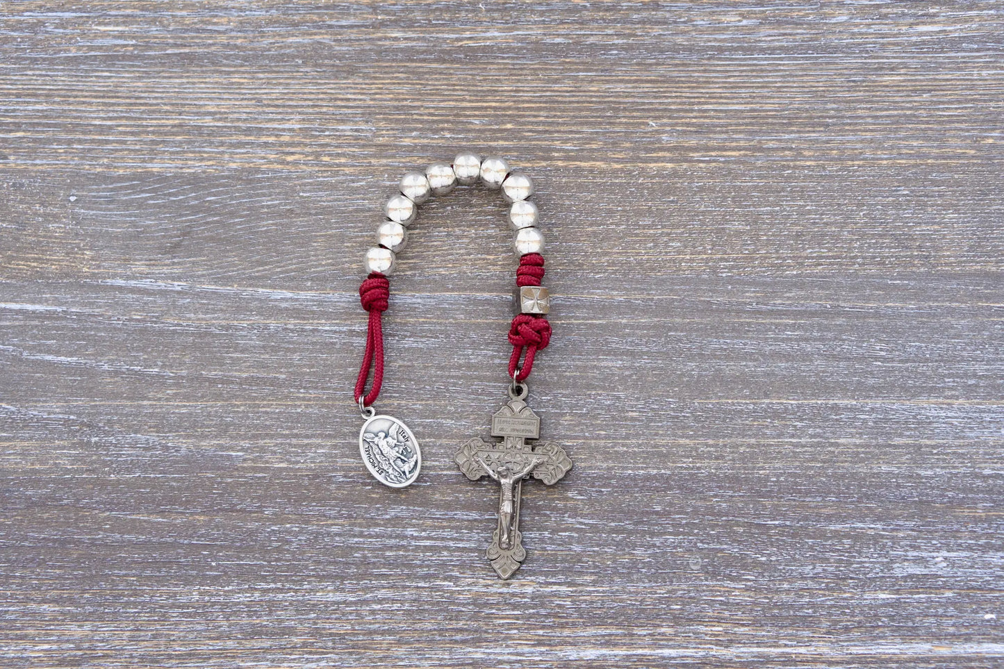Premium metal pocket paracord rosary with gunmetal pardon crucifix, available in navy, maroon, or iron gray.