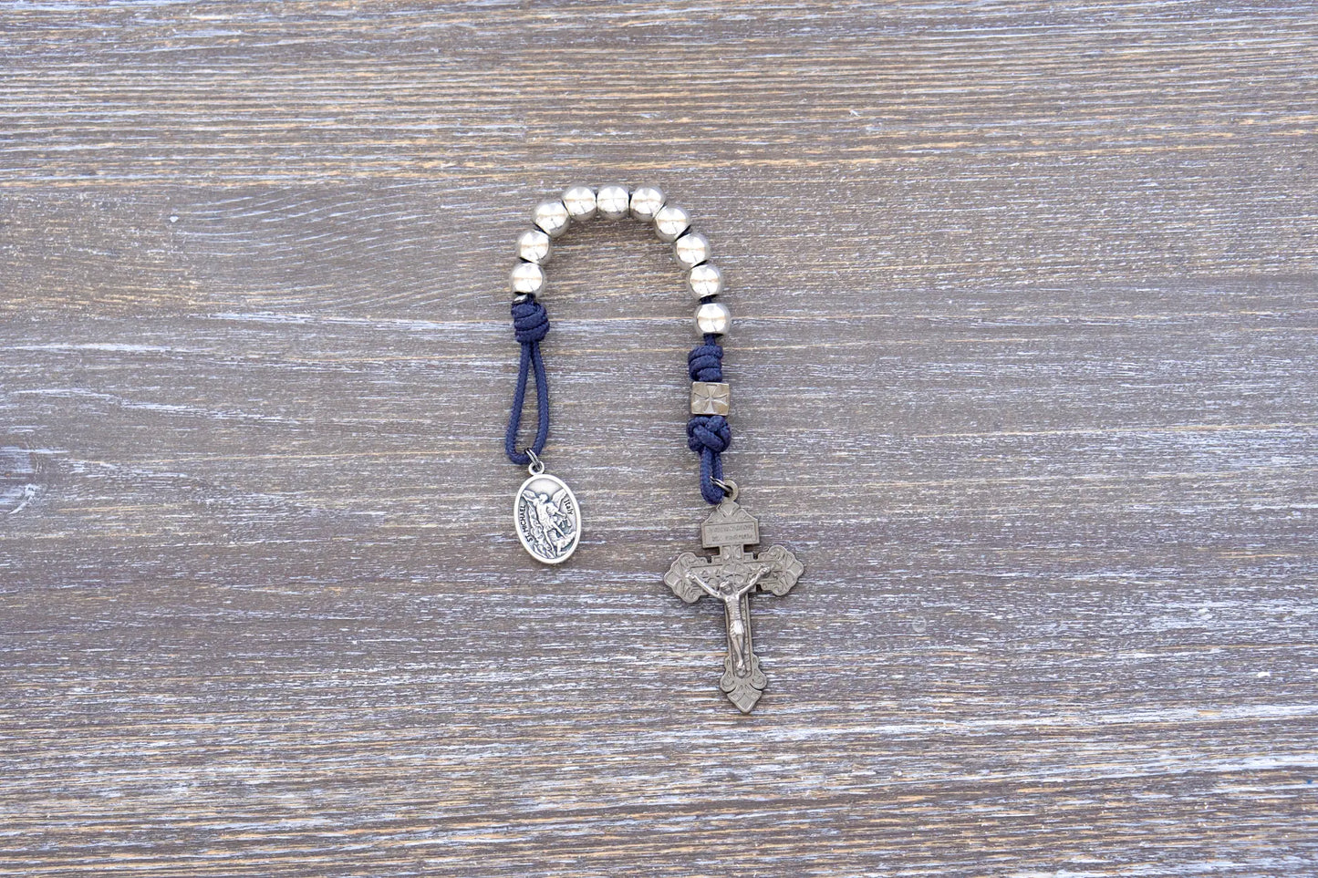 Reclaim Christendom rosary in premium metal paracord with gunmetal crucifix, available in navy, maroon, or iron gray.