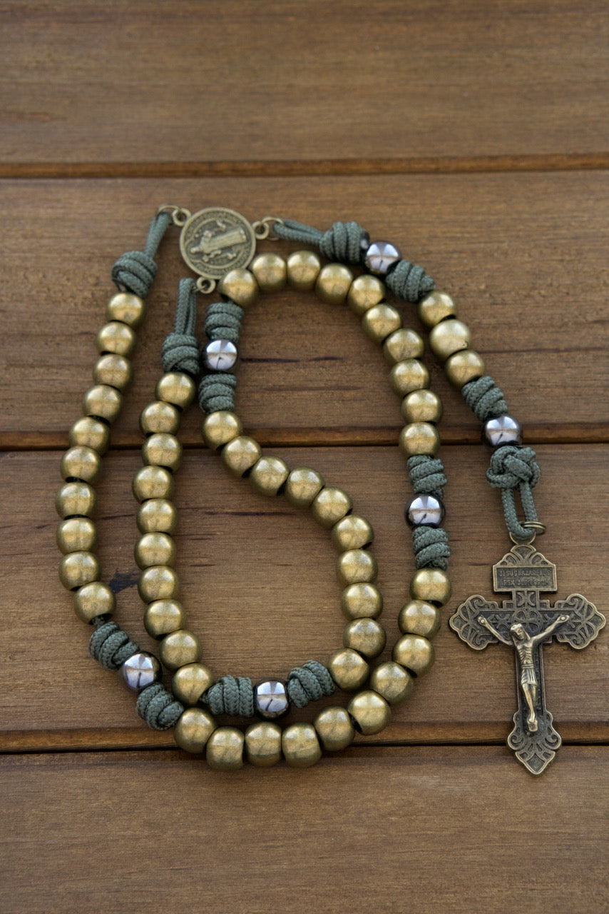 Sacred Steel - Stainless Steel Catholic Paracord Rosary featuring high-quality dark forest green paracord, olive stainless steel beads, gunmetal Our Father beads, a protective olive St. Benedict medal, and a 2" Pardon Crucifix. 
