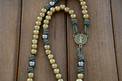 Crafted with precision and care, this durable paracord rosary features high-quality dark forest green 275 paracord, stainless steel olive 10mm Hail Mary beads, and gunmetal Our Father beads. The stunning olive St. Benedict medal offers protection and spiritual guidance, while the 2" Pardon Crucifix serves as a reminder of Jesus' ultimate sacrifice. 