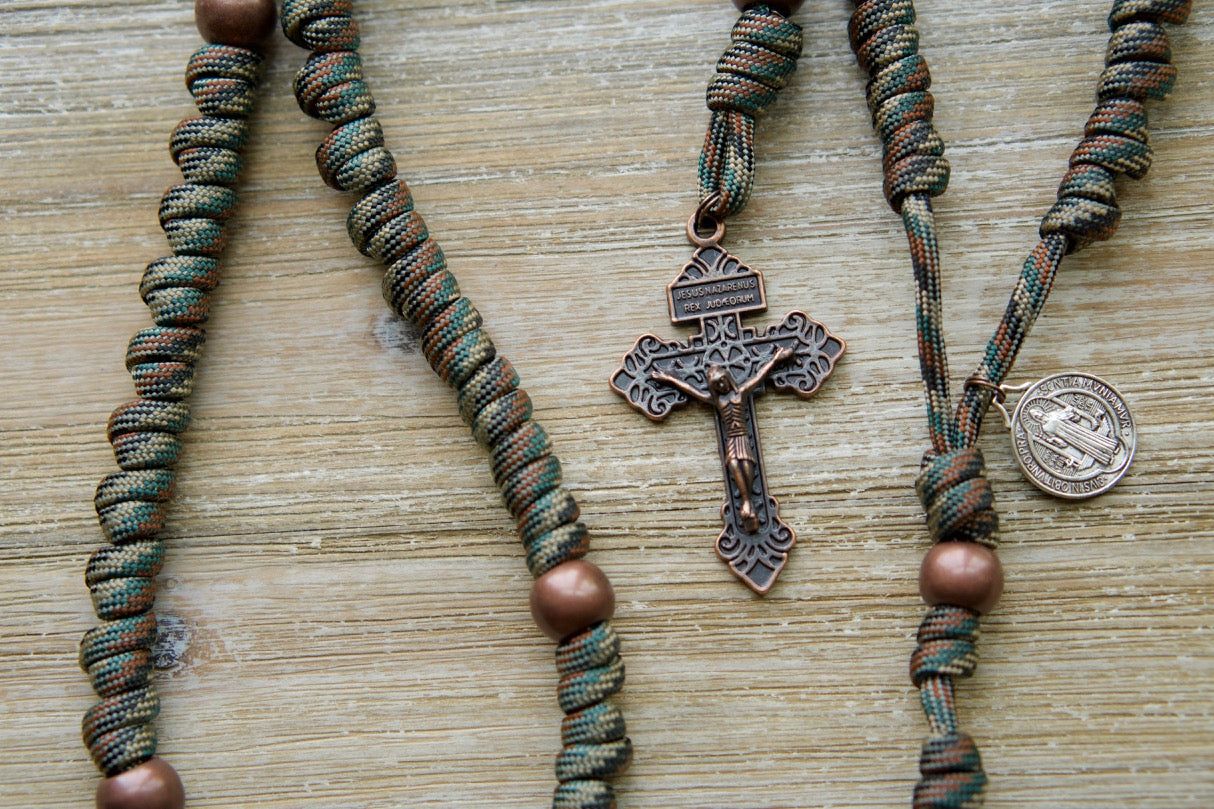 The Serpent Slayer - Camo and Copper - Knotted Rope Rosary: A durable, premium, unbreakable paracord rosary that's perfect for your spiritual weapon against evil. With a bold camo and copper design, standard 2" Antique Copper Pardon Crucifix, St. Benedict devotional medal, and rigorous kid-testing to ensure it won't break. Foldable storage in pocket for easy on-the-go use.
