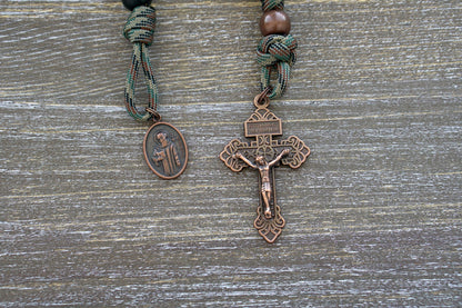 "The Serpent Slayer" Pocket Paracord Rosary - A powerful, matte black and antique copper rosary with a pardon crucifix and St. Benedict medal, designed for devout Catholics to combat evil in their lives.