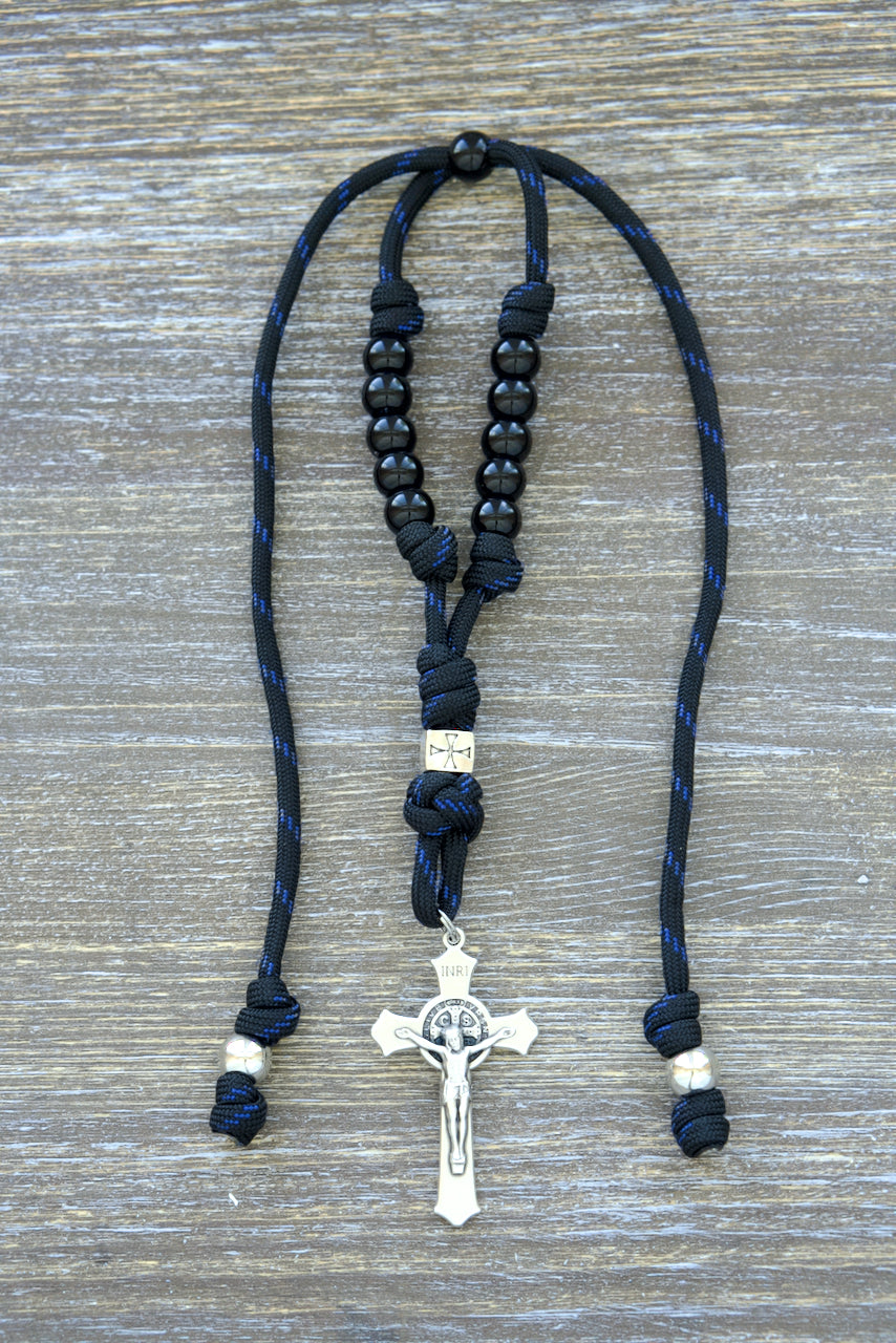 Catholic rearview mirror rosary featuring black paracord, navy blue accents, silver crusader metal alloy Our Father bead, shiny black Hail Mary beads, and a 2-inch St. Benedict crucifix, ideal for daily spiritual practice in the car.